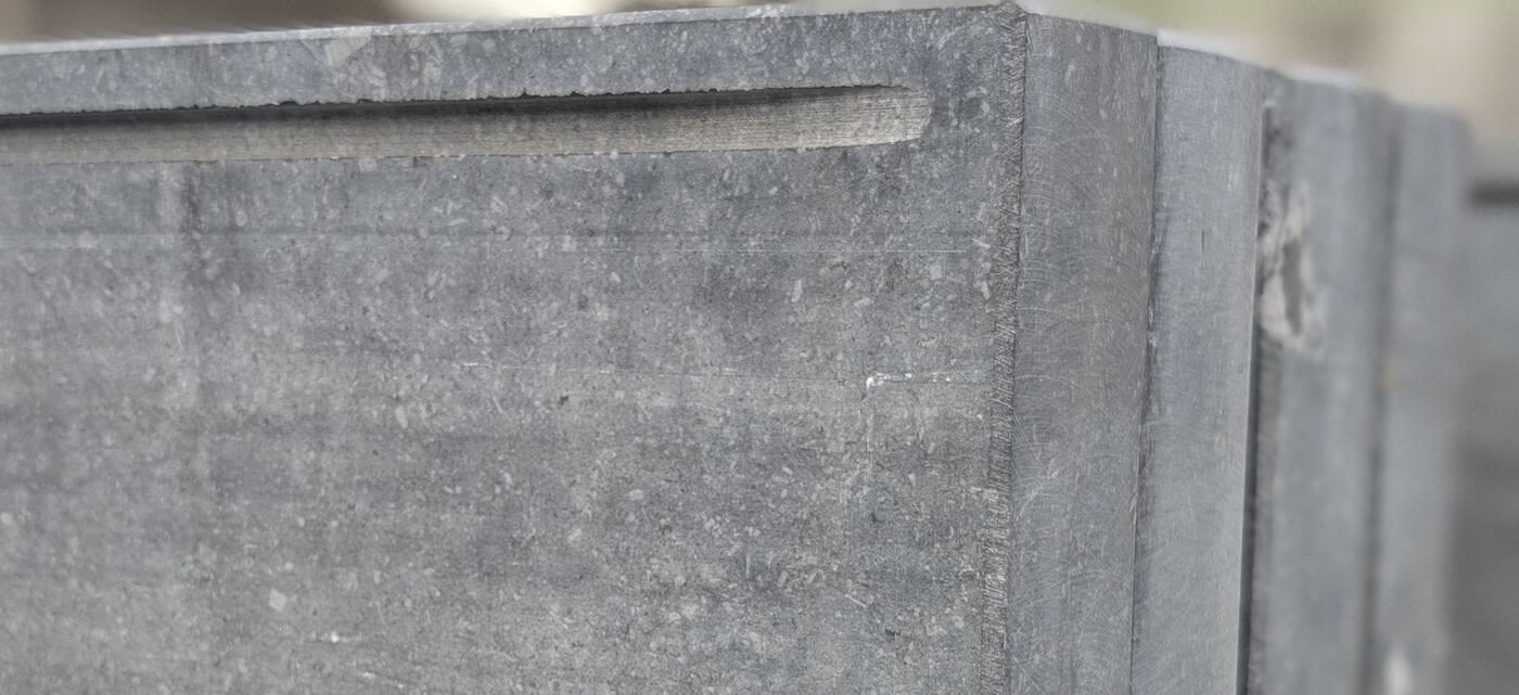 Detail van een dikke blauwsteen op maat met een gezaagde groef langs de rand